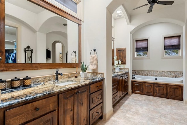 bathroom featuring a bathing tub, vanity, and ceiling fan