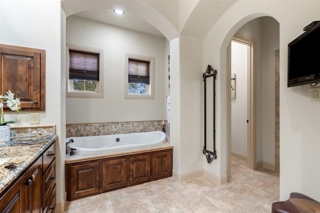 bathroom with vanity and a tub to relax in