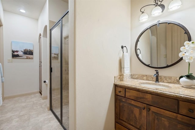 bathroom with vanity and a shower with door