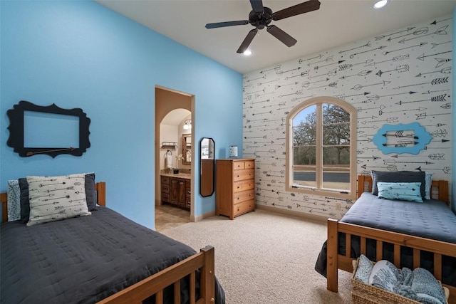 bedroom with connected bathroom, ceiling fan, and light colored carpet