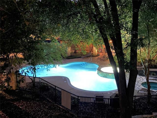 view of swimming pool featuring a patio area and an in ground hot tub