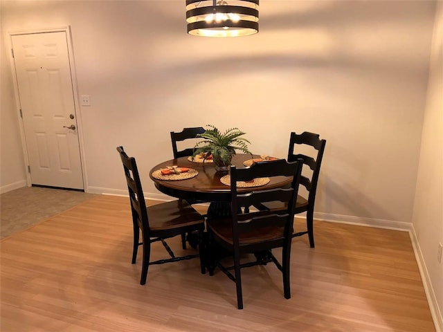 dining space featuring a notable chandelier and light hardwood / wood-style floors