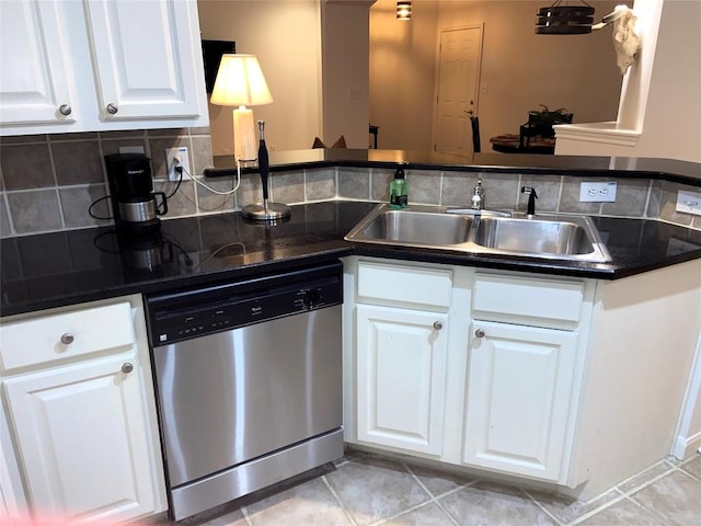 kitchen with tasteful backsplash, stainless steel dishwasher, sink, white cabinets, and light tile patterned flooring