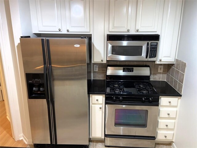 9525 N Capital Of Texas Hwy Unit 623, Austin, TX 78759 - kitchen with appliances with stainless steel finishes, dark countertops, white cabinetry, and decorative backsplash