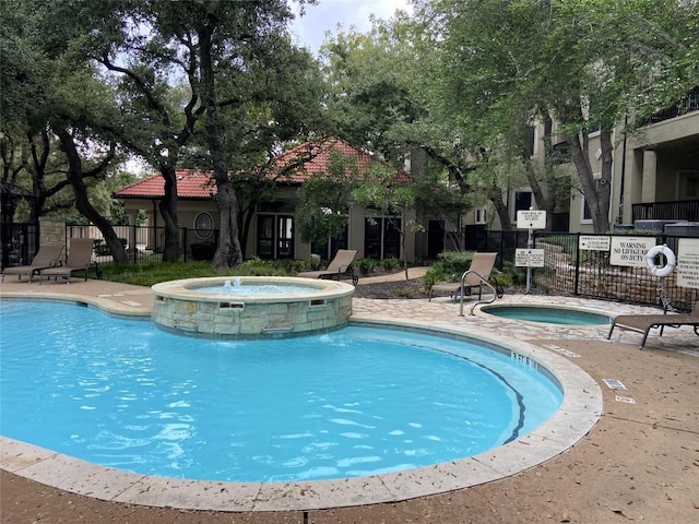 view of pool featuring pool water feature and a community hot tub