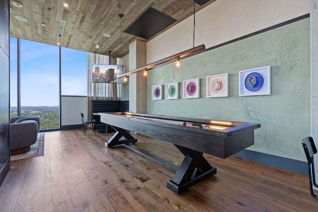 playroom with a towering ceiling, hardwood / wood-style flooring, and expansive windows