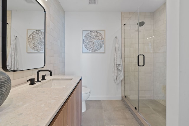 bathroom featuring tile patterned floors, vanity, a shower with shower door, and toilet