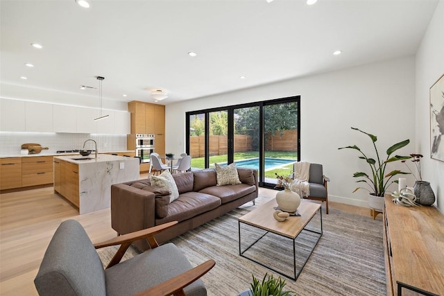 living room with light hardwood / wood-style flooring and sink