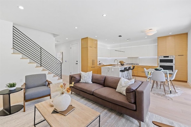 living room featuring sink and light hardwood / wood-style floors