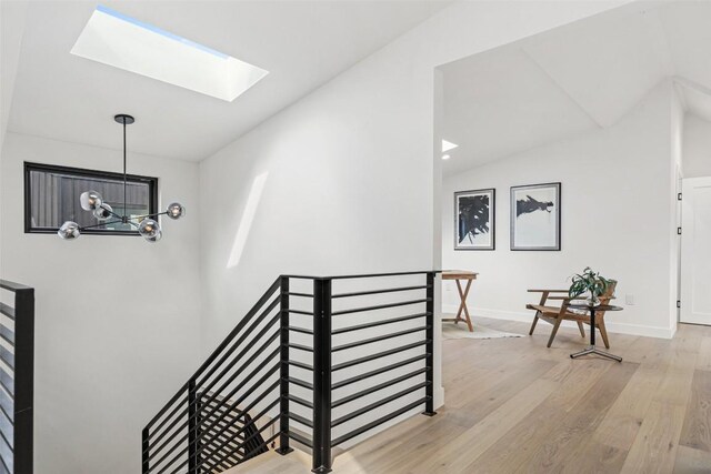4505 Shoal Creek St, Austin, TX 78756 - staircase featuring a skylight, hardwood / wood-style floors, a chandelier, and vaulted ceiling