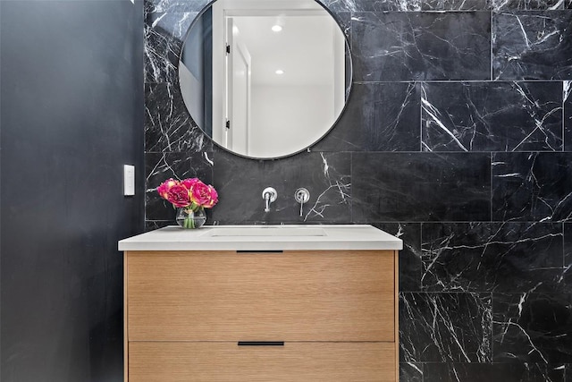 bathroom featuring vanity and tile walls