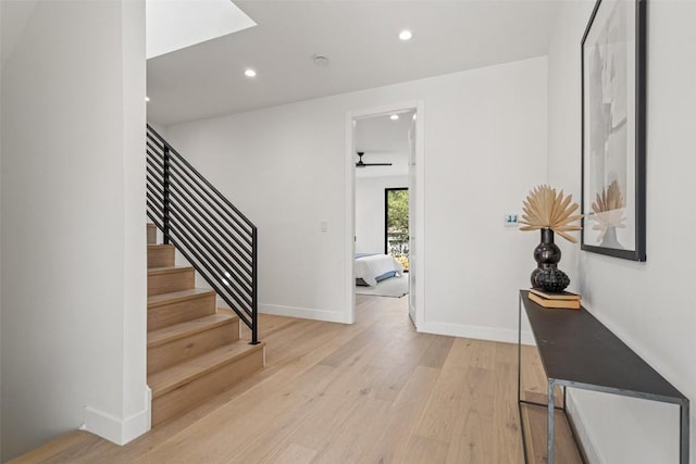 staircase with wood-type flooring and ceiling fan