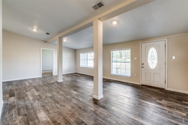 entryway featuring vaulted ceiling with beams, dark wood-style flooring, visible vents, and baseboards