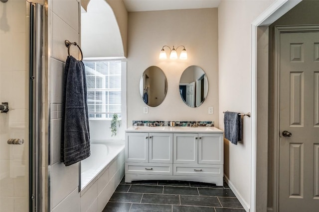 full bath with a garden tub, double vanity, a tile shower, baseboards, and tile patterned floors