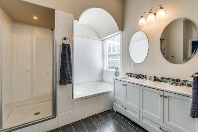 bathroom featuring a stall shower, tile patterned flooring, a sink, and a bath