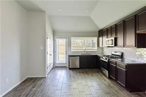 kitchen with dark brown cabinets, stainless steel appliances, and tasteful backsplash