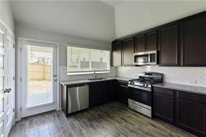 kitchen featuring hardwood / wood-style floors, sink, dark brown cabinetry, and stainless steel appliances