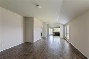 unfurnished living room with lofted ceiling and dark wood-type flooring