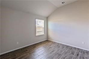 unfurnished room featuring dark hardwood / wood-style flooring and lofted ceiling