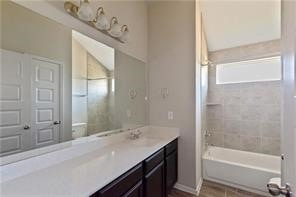 bathroom with vanity and tiled shower / bath