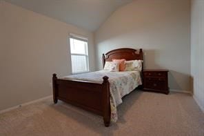 bedroom with light colored carpet and vaulted ceiling