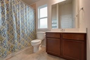 bathroom with a shower with shower curtain, vanity, a healthy amount of sunlight, and toilet