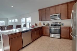 kitchen with kitchen peninsula, sink, and appliances with stainless steel finishes