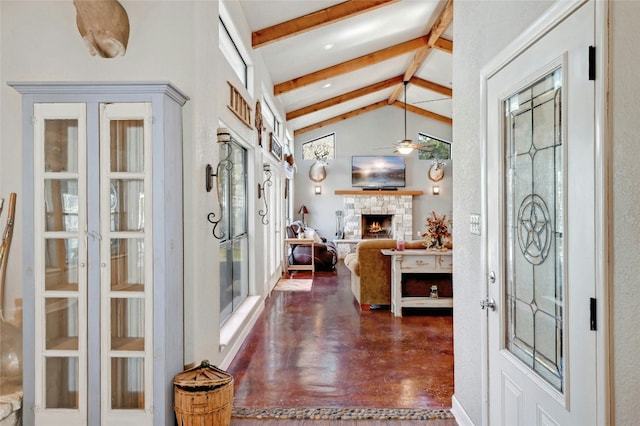 entrance foyer featuring vaulted ceiling with beams, ceiling fan, and a stone fireplace