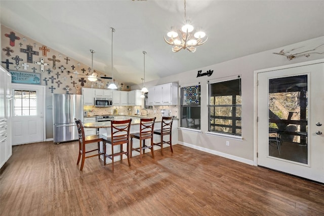 dining area with dark hardwood / wood-style flooring, high vaulted ceiling, and a chandelier