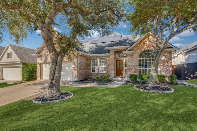 view of front of property with solar panels, a garage, and a front yard