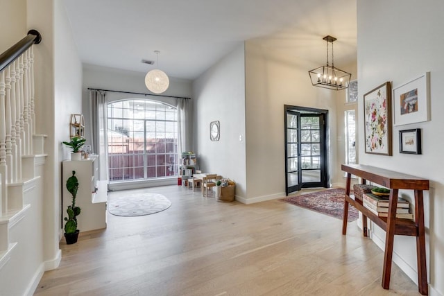 foyer entrance featuring light wood-type flooring and a notable chandelier