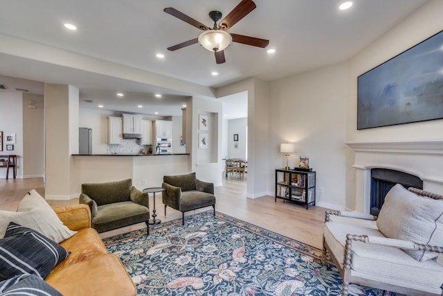 living room with ceiling fan and light wood-type flooring