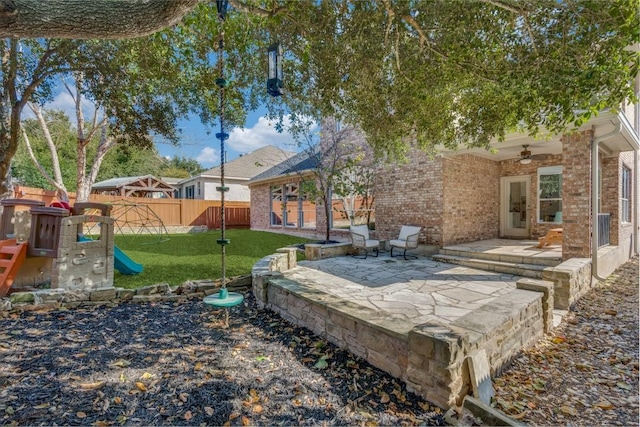 view of yard with ceiling fan and a patio