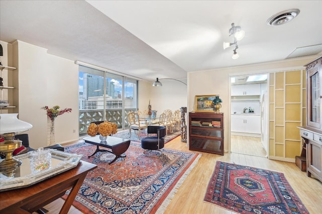 living room featuring light hardwood / wood-style flooring and floor to ceiling windows