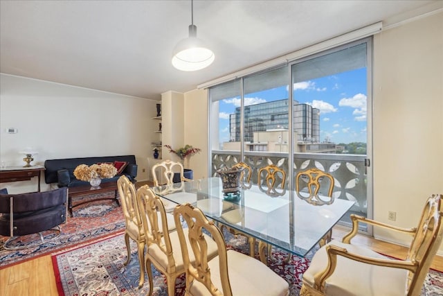 dining area with wood-type flooring and floor to ceiling windows