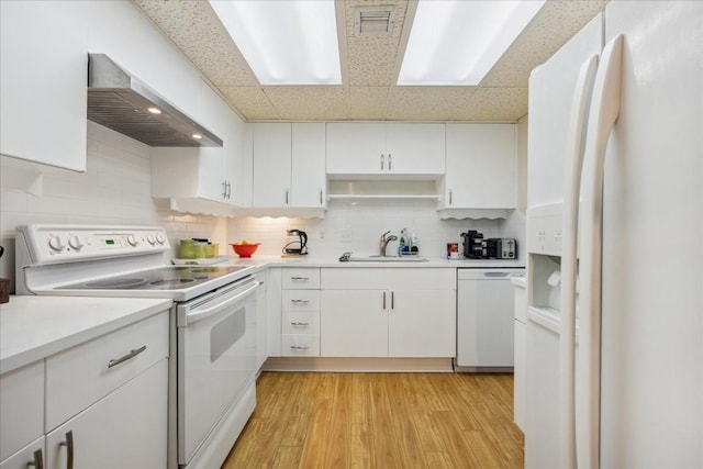 kitchen featuring white cabinetry, wall chimney range hood, light hardwood / wood-style floors, white appliances, and decorative backsplash