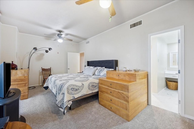 bedroom featuring connected bathroom, ceiling fan, and light colored carpet