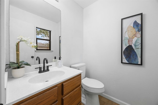 bathroom featuring hardwood / wood-style floors, vanity, and toilet