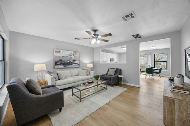 living room featuring ceiling fan and light hardwood / wood-style flooring