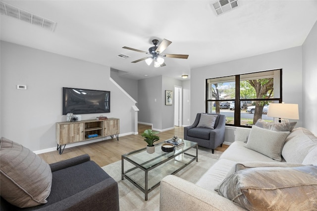 living room with light hardwood / wood-style flooring and ceiling fan