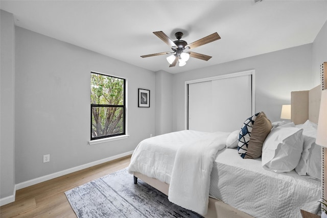 bedroom featuring ceiling fan, a closet, and wood-type flooring