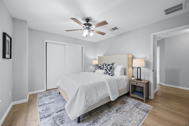 bedroom featuring ceiling fan, a closet, and light hardwood / wood-style flooring