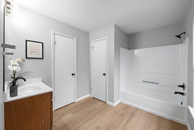 bathroom with hardwood / wood-style floors, vanity, and shower / washtub combination