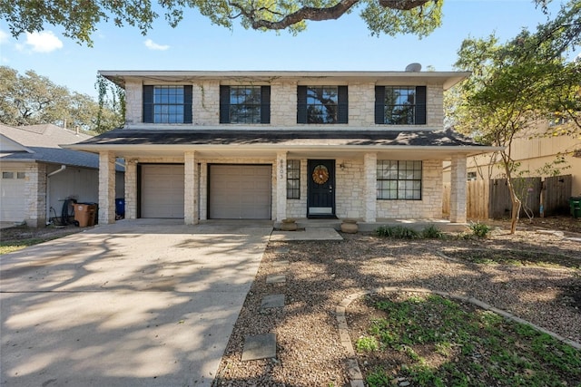 view of front facade with fence, an attached garage, stone siding, driveway, and covered porch