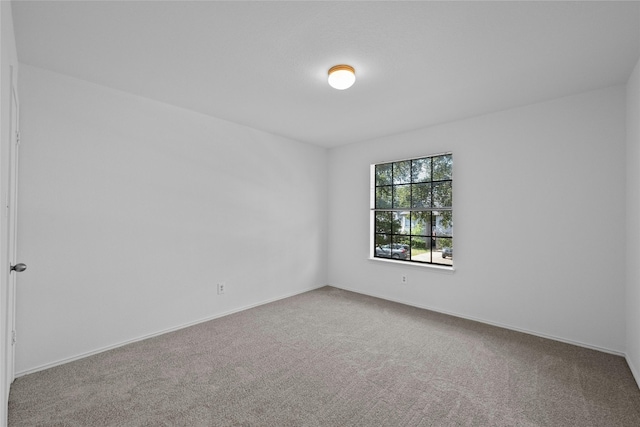carpeted empty room with baseboards