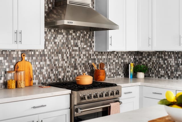 kitchen featuring high end stainless steel range, decorative backsplash, and extractor fan