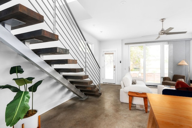 living room featuring ceiling fan and concrete flooring