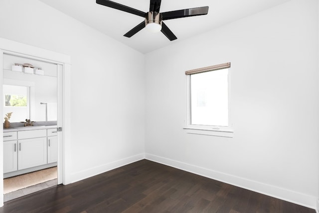 spare room featuring dark hardwood / wood-style floors, ceiling fan, and sink