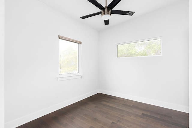 spare room with a healthy amount of sunlight, ceiling fan, and dark wood-type flooring