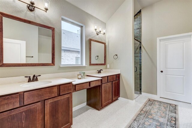 bathroom featuring walk in shower, vanity, vaulted ceiling, and tile patterned flooring